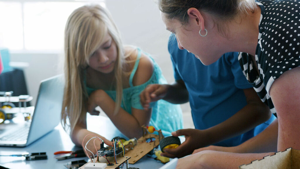 students with teacher in school computer coding class